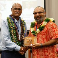 Dr Donald Wilson (right) receiving his fellow plaque from the PAS President Professor Teatulohi Matainaho